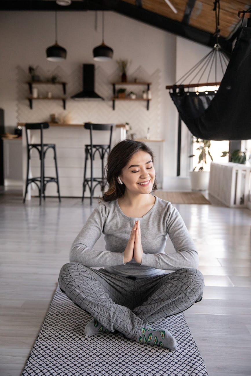 ethnic woman sitting in namaste pose while practicing yoga