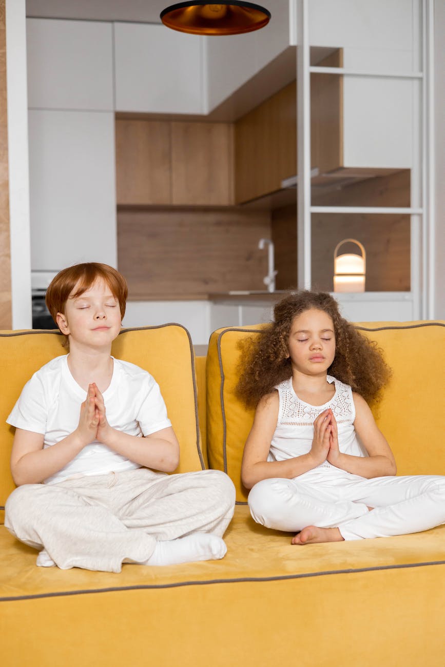 a girl and a boy in a yoga seated pose